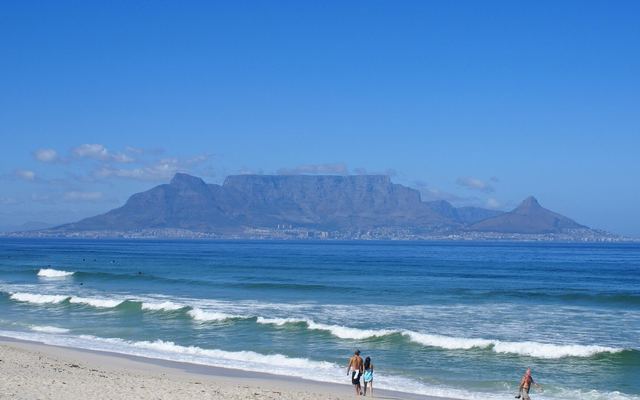 De Tafelberg gezien vanaf het strand van Bloubergstrand met golven op de voorgrond