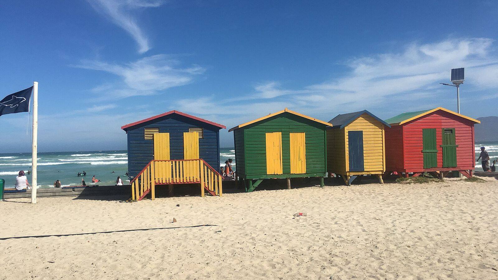 De rij felgekleurde strandhuisjes op het strand van Muizenberg