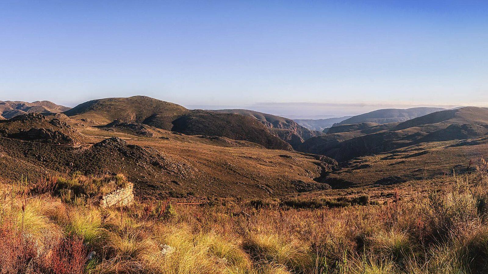 De kronkelende grindweg van de Swartbergpas tussen steile rotswanden