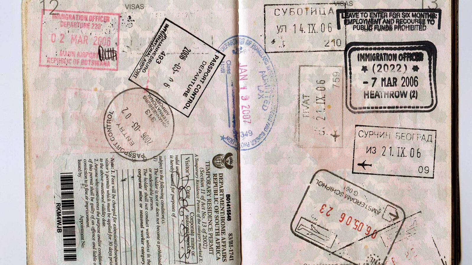 Paspoort met inreisstempels op een tafel naast een vliegticket